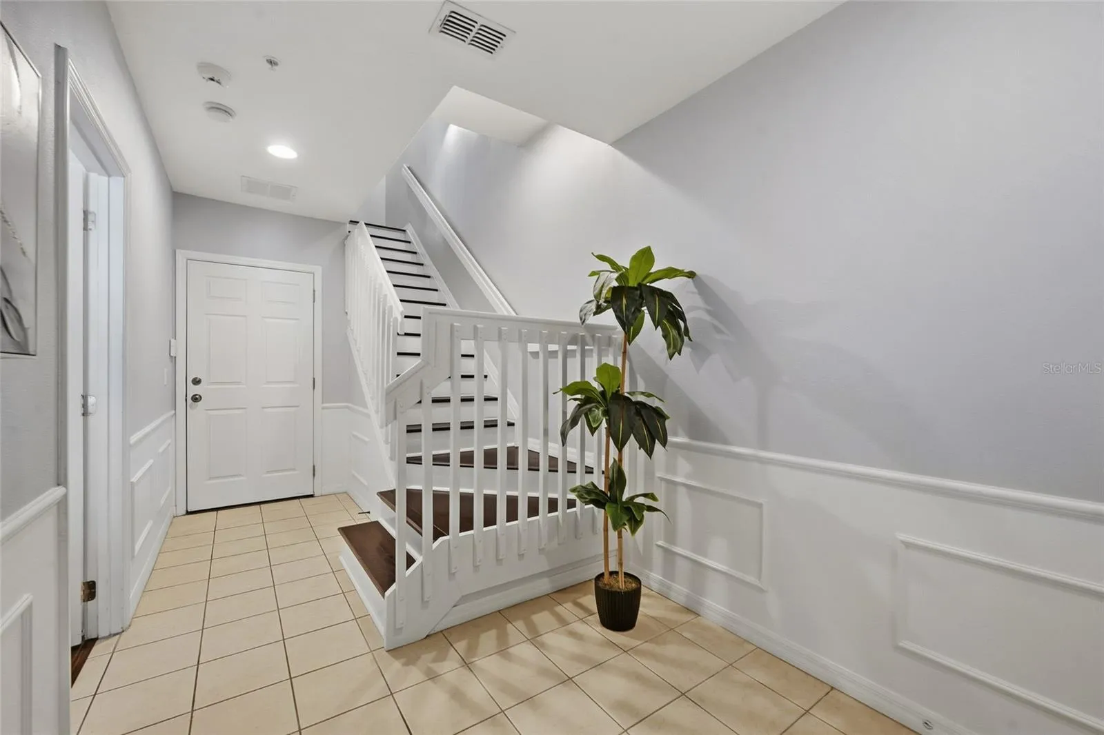 Welcoming entry with classic wainscoting and staircase connecting all three levels.  Garage Entrance