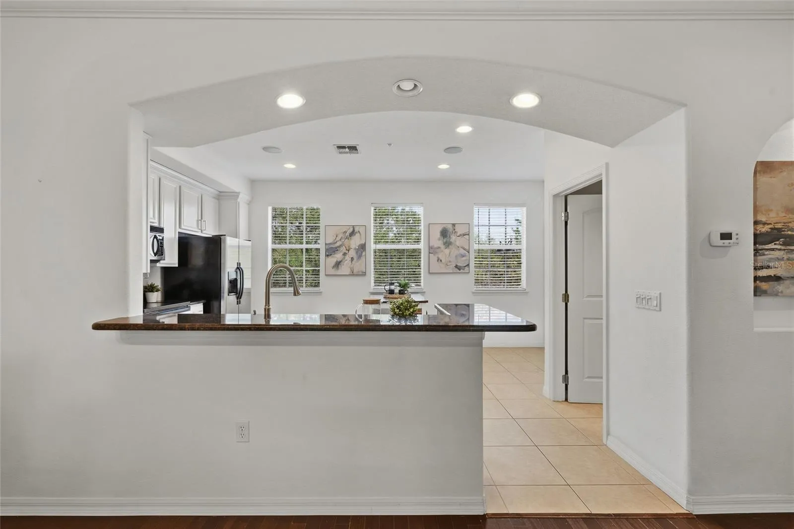 Open kitchen with breakfast bar overlooking the main living and dining spaces.