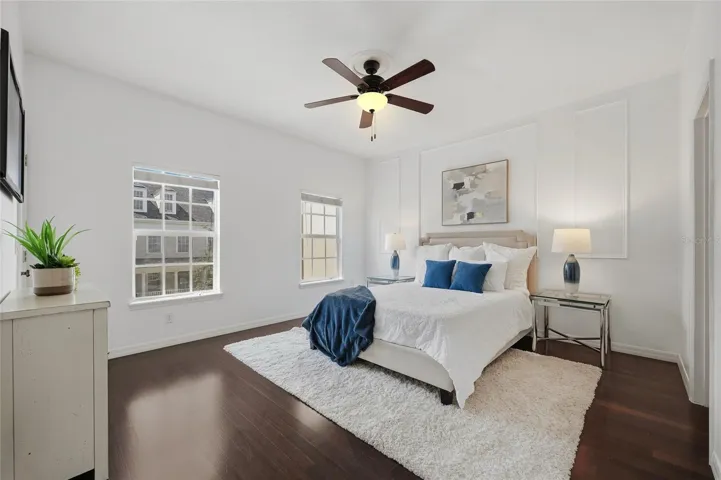 Primary Bedroom Spacious primary suite with hardwood flooring, abundant natural light and elegant feature-wall detailing.