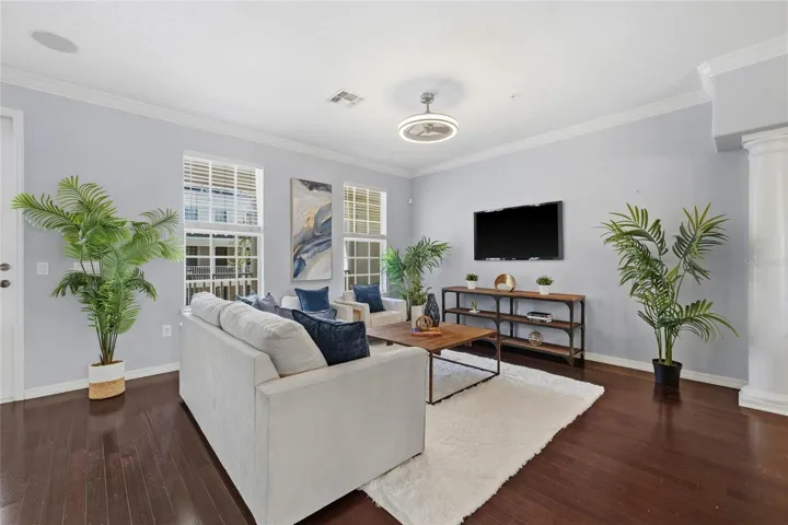 Bright, spacious living room with hardwood flooring, large windows and plenty of room for multiple seating arrangements.