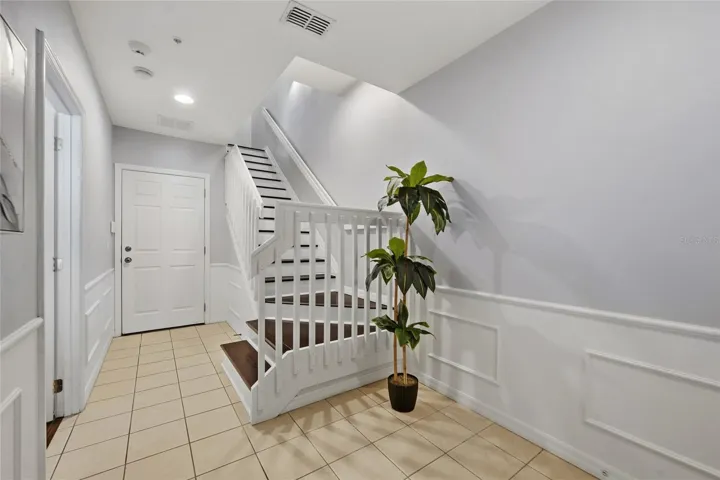 Welcoming entry with classic wainscoting and staircase connecting all three levels.  Garage Entrance