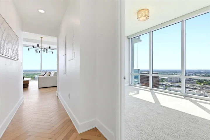 Just outside the primary suite, the hallway connects to a secondary bedroom on the right, with a full bath directly across.