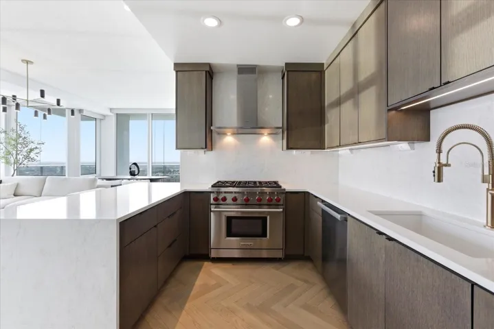 Rift oak cabinetry - aligned with today's most refined interiors - sets a tone of quiet luxury, layered with continuous quartz, a Wolf range, and a champagne gold Brizo faucet that adds a subtle polished finish.