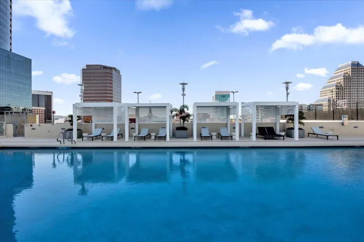 Pool deck with cabanas and city view.