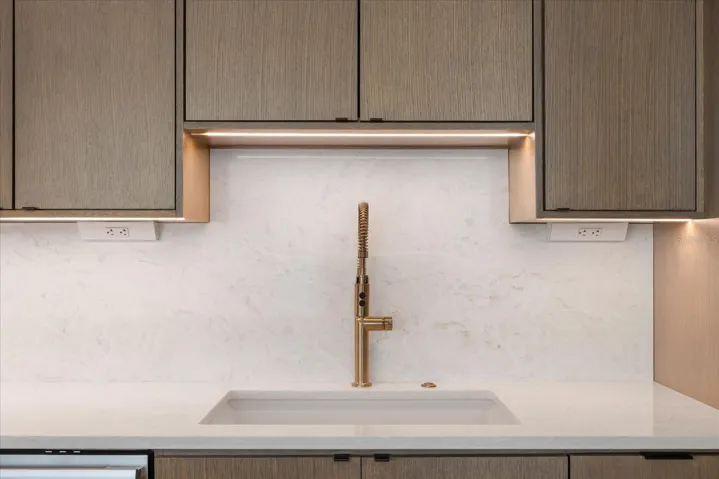 Champagne gold faucet accents across quartz