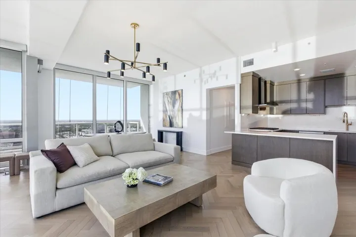 The living space extends seamlessly toward the kitchen, maintaining a continuous architectural flow.