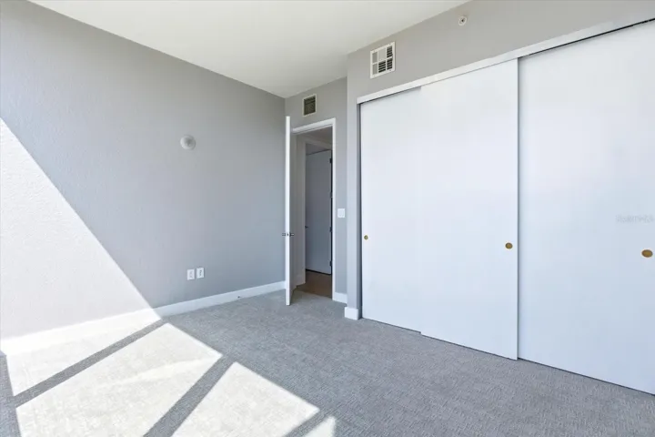 Secondary bedroom with closet storage and natural light.