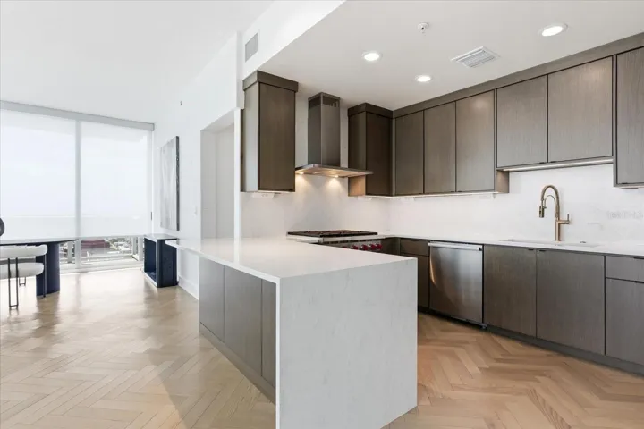 Centered around a generous island, the kitchen settles into the afternoon as motorized shades soften the western light - creating a calm, more private atmosphere.