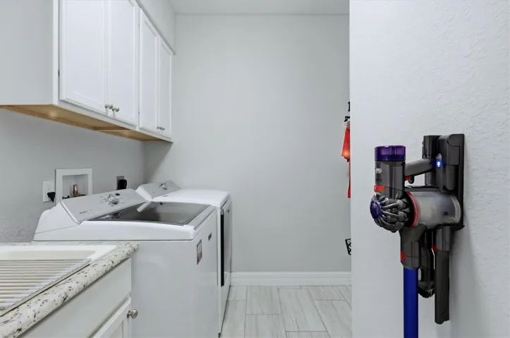 Big Laundry room with mop sink and extra hanging room and cabinets