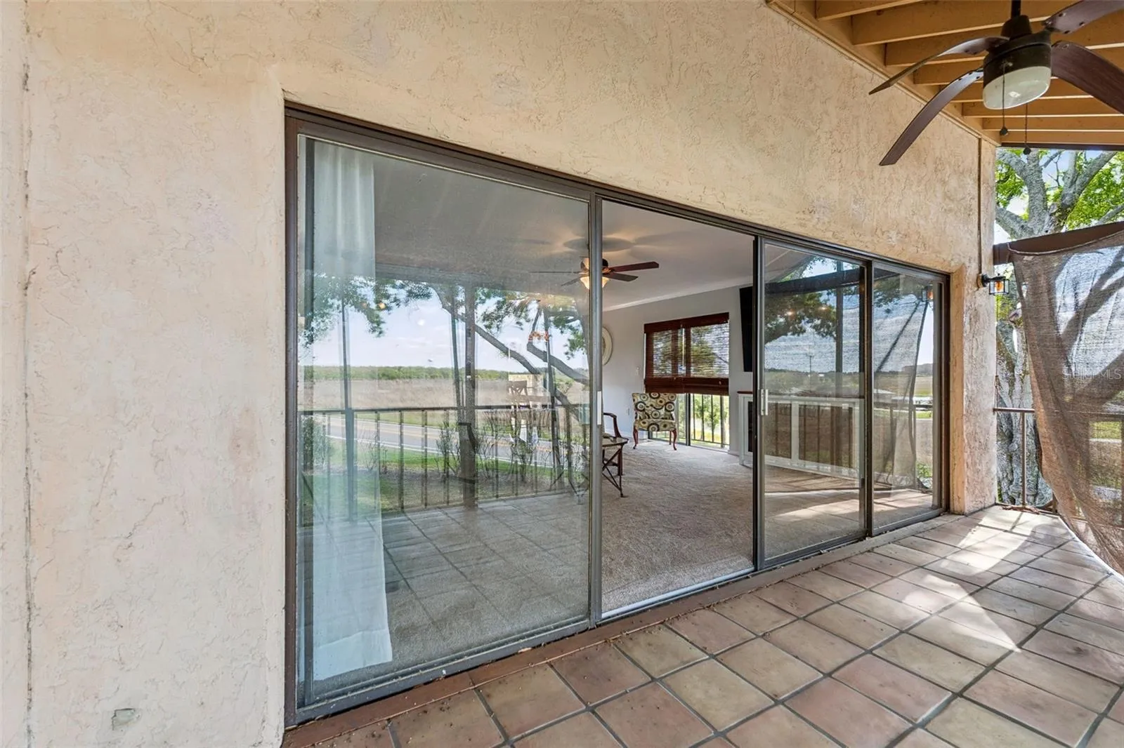 Double sliding doors open onto porch with tile floor