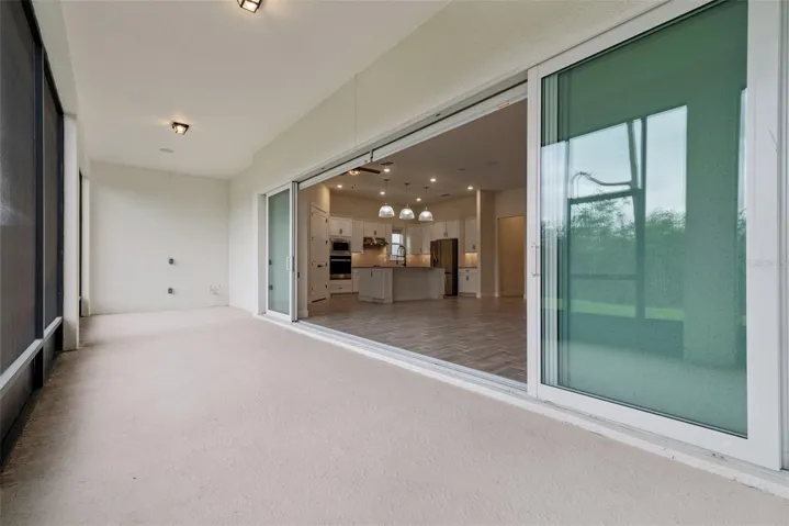 Giant screened back porch with sliders that feed into the walls maximizing your indoor / outdoor living space.  The space has been pre-plumbed for a summer kitchen on the back wall in this photo.
