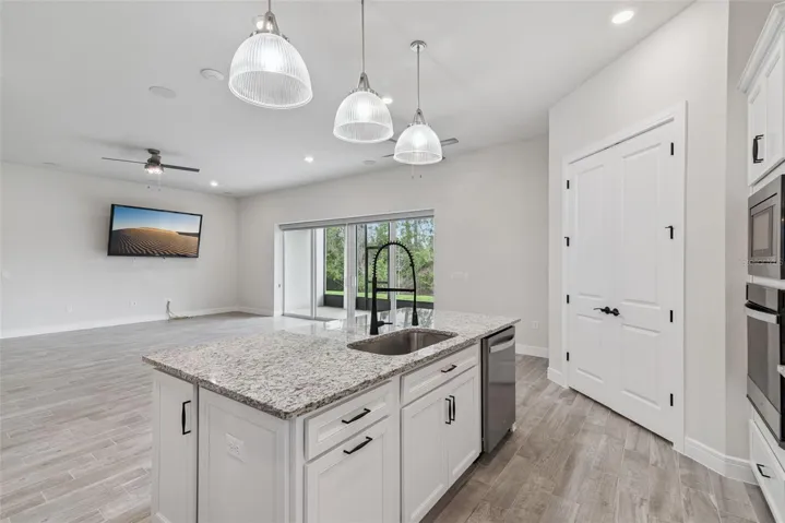 Open views from the kitchen to the great room and beyond to the screened in back porch.