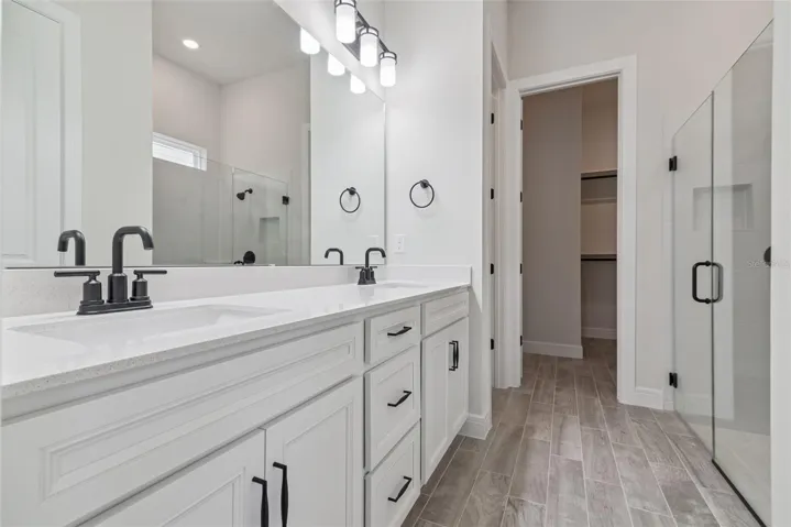 Primary suite bathroom has quartz countertops, soft close cabinets and oversized shower