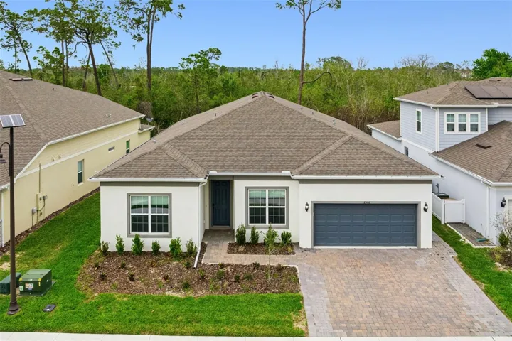 Single Story 5 bedroom property with oversized paver driveway and full conservation behind.