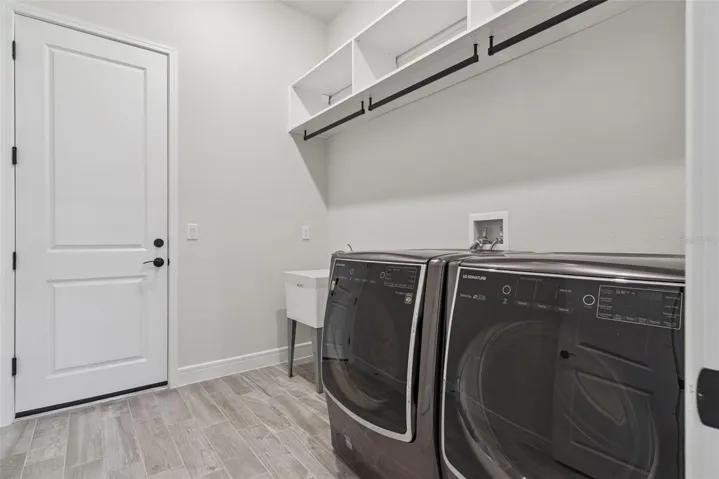 Laundry room includes the LG washer and dryer and has been outfitted with California closet shelves and hanging system.   and of course, has an oversized laundry tub.