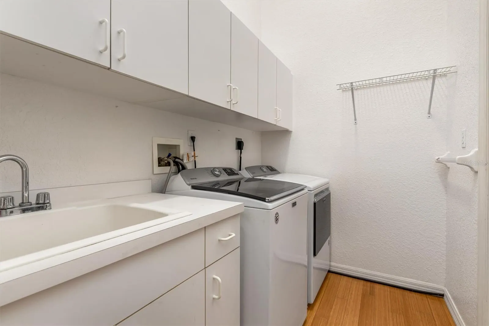 Interior laundry room with washer, dryer, and utility sink.