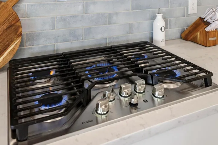 Upgraded kitchen with this GE-Profile gas cooktop & range hood