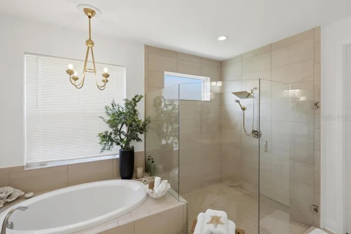 Oversized walk-in shower with custom stylish lightning and faucets