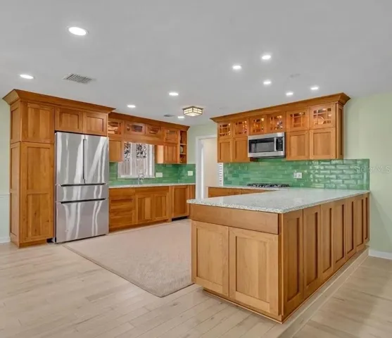 Updated kitchen with Bosch appliances, cherry wood cabinetry, and man-made glass countertops
