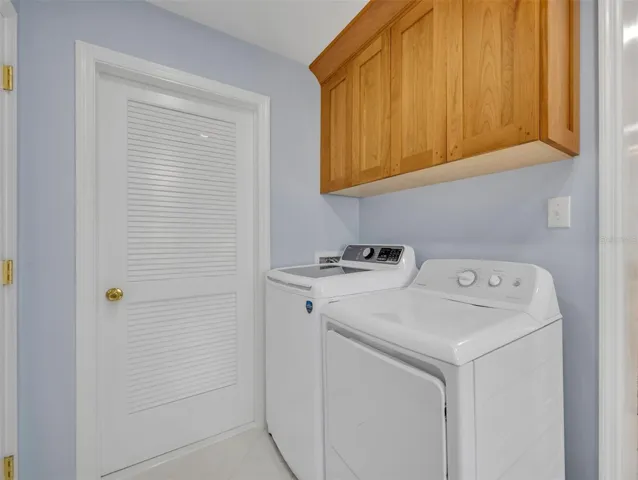 Indoor laundry room with cabinets and cedar storage closet
