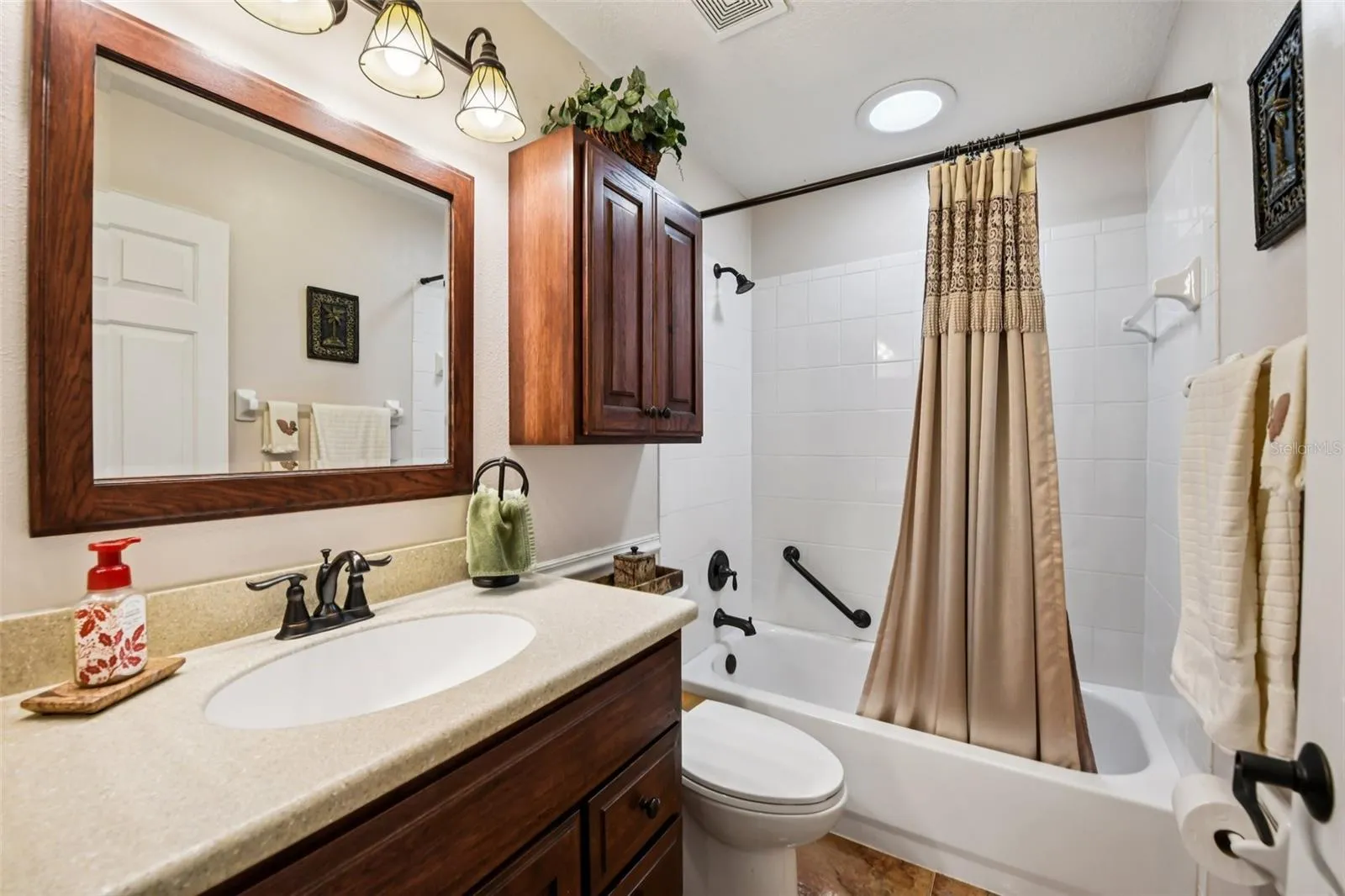 Guest bath with wood cabinets and Corian counter tops, Ceramic tile floors.