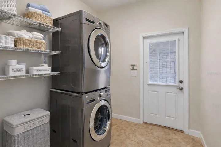 CONVENIENT LAUNDRY ROOM with FULL-SIZE WASHER & DRYER and BUILT-IN STORAGE.