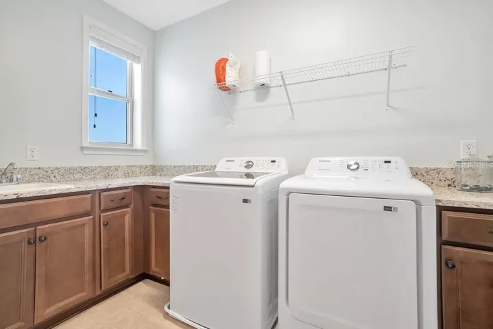 The UPSTAIRS LAUNDRY ROOM—complete with cabinets, counter space, and built-in sink—makes everyday living effortless.