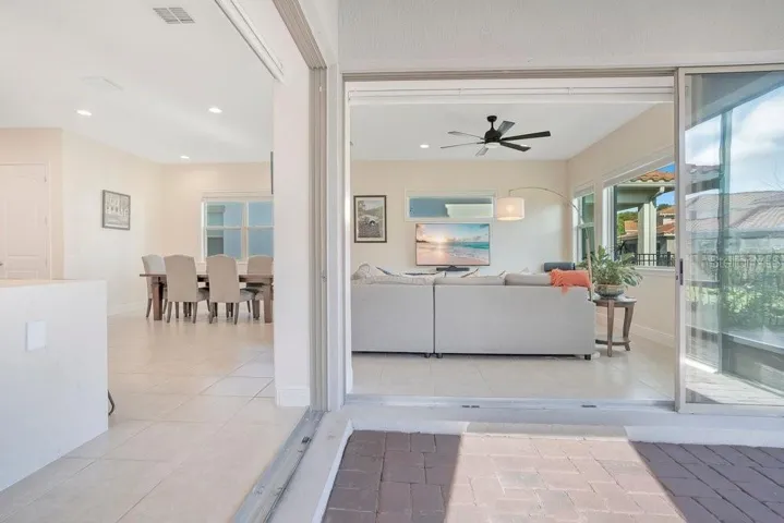 Expansive CORNER SLIDING GLASS DOORS lead to a screened-in covered porch, creating the perfect indoor-outdoor living experience.