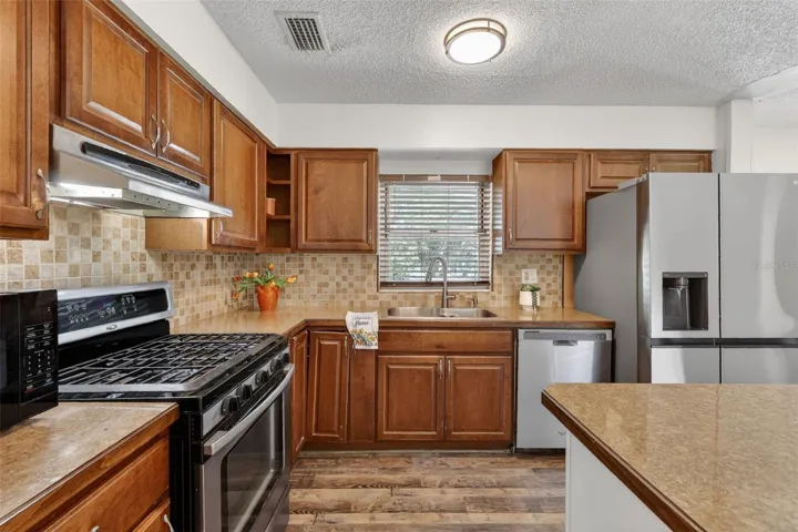 Kitchen - stainless appliances, newer refrigerator, granite counters, wood cabinets.