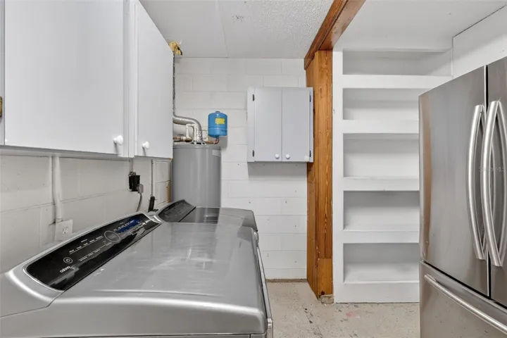 Laundry Room with additional refrigerator and storage shelves.
