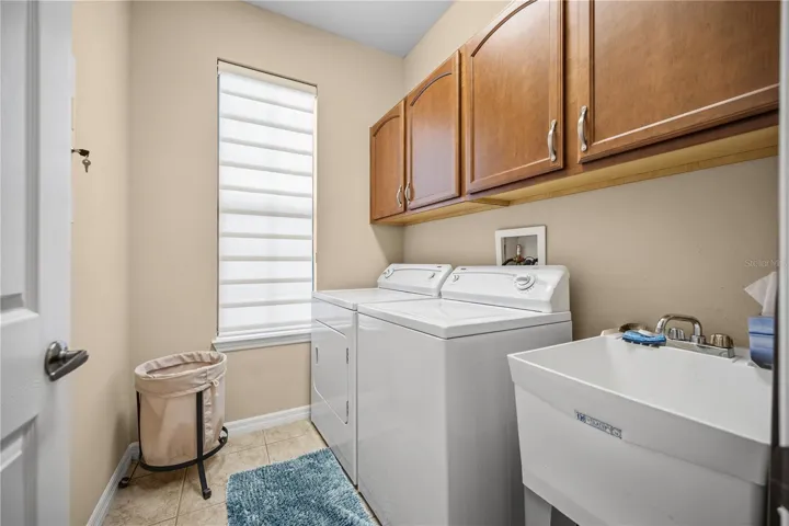 Laundry room just inside from the garage, boasts a Tub Sink and Storage Cabinets!