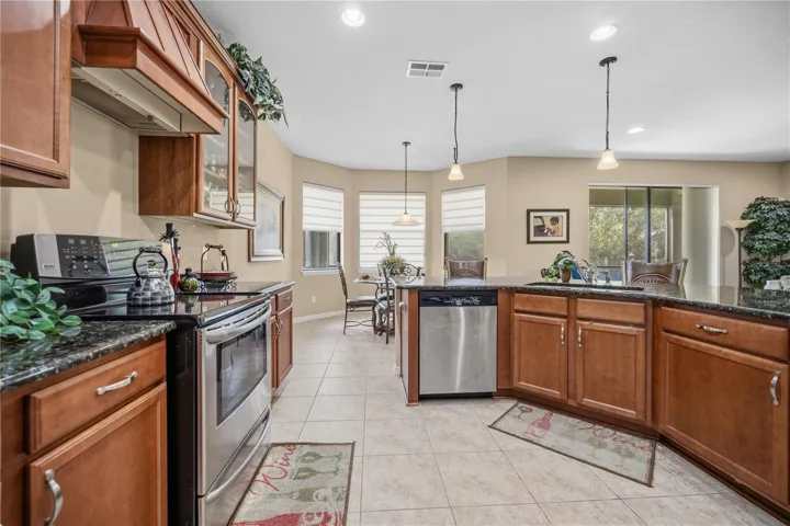 Solid wood Maple Cabinets, Granite Countertops, Generous Island with Bar seating and Stainless appliances adorn this Spacious kitchen!! All the UPGRADES!!