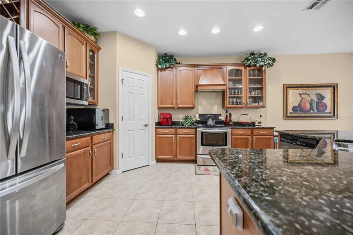 Kitchen view Shows ample storage in the solid Maple Wood Cabinets with Glass door features, wine rack,  Spacious Closet Pantry, Granite Countertops, & Breakfast Bar Island!!