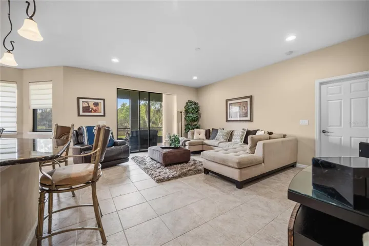 Spacious Family room view ,  Neutral Color tile, Great room layout flows into the Kitchen . Features  Sliding doors leading to the Lanai.