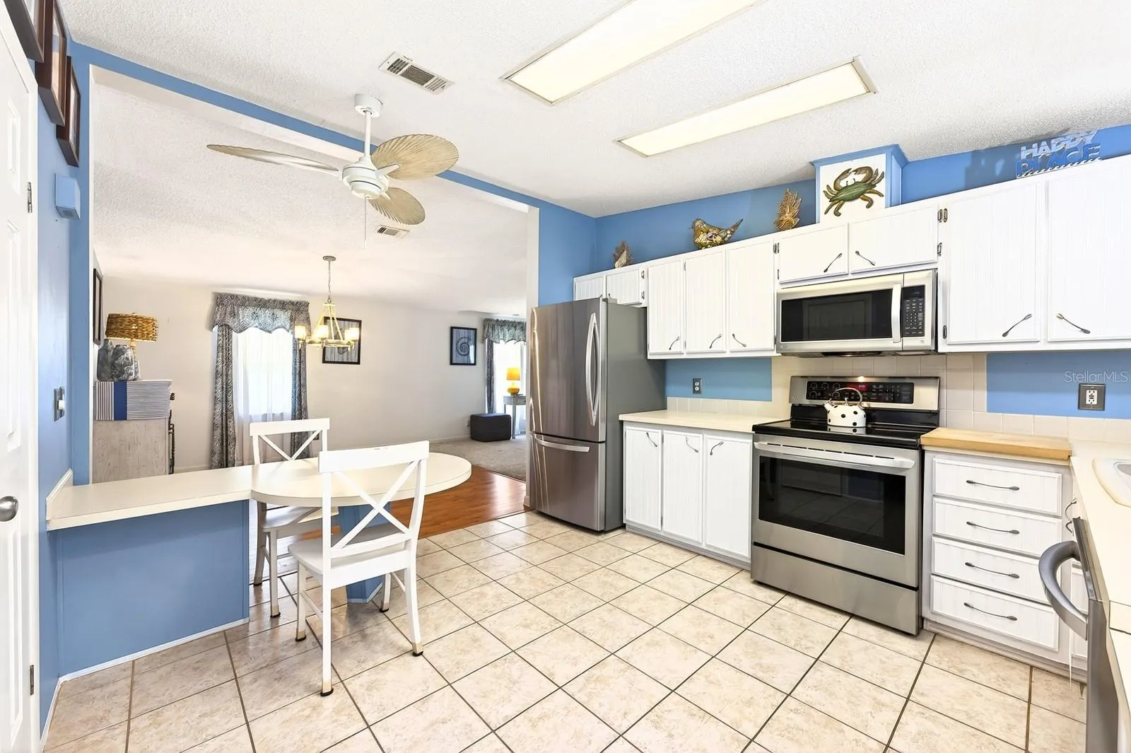 The kitchen stands out with a vaulted ceiling, solid wood cabinetry, tiled backsplash, pantry storage, a built-in desk, and a cozy breakfast nook.