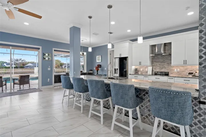 Kitchen has custom backsplash and a stone accent wall. This Chefs kitchen has been completely remodeled with new white shaker cabinets, a large breakfast bar, built in oven and microwave and granite countertops.