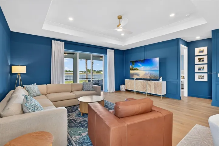 Living room featuring a ceiling fan, recessed lighting, and decorative molding