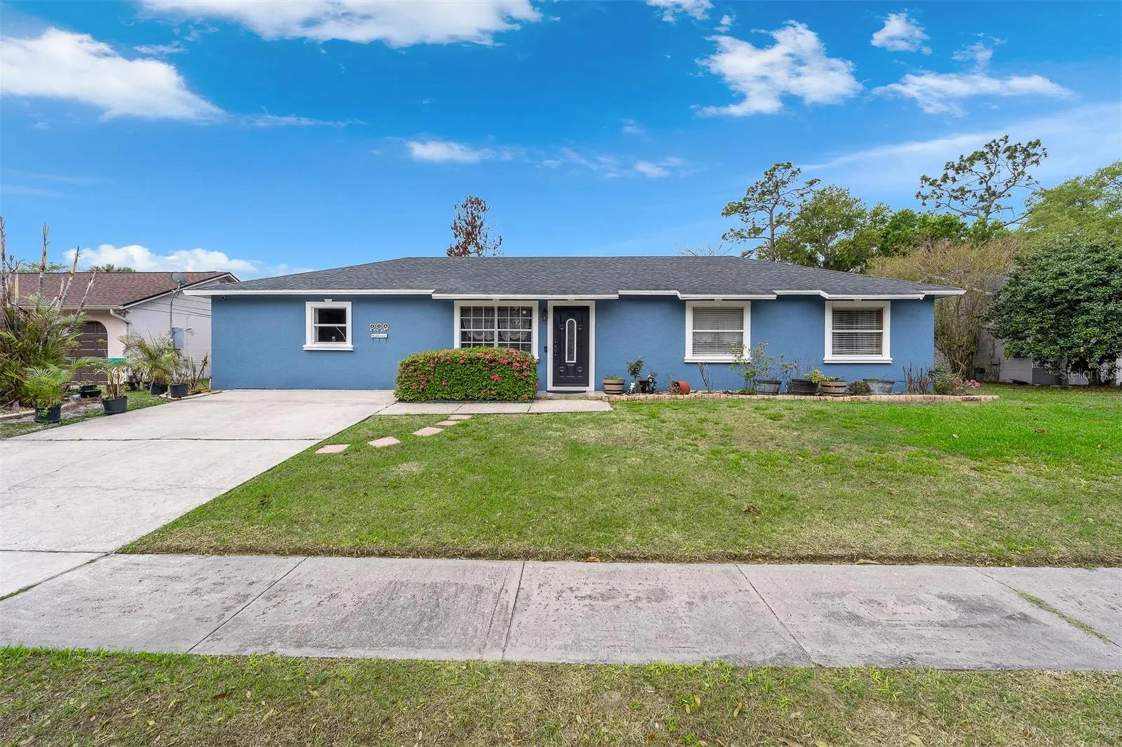 Another view of the front elevation showing the lawn, walkway, and exterior paint condition.