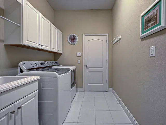 Interior laundry room has tub, more storage and leads directly to the garage.