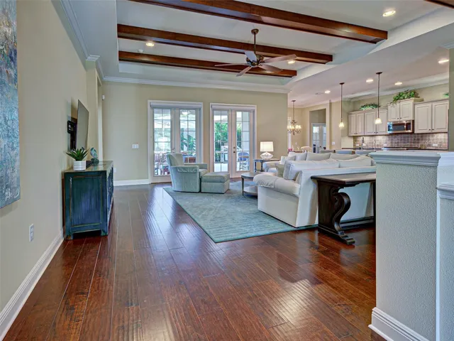 Great room has stunning tray ceiling and wood beams and hurricane impact French doors.  All the windows have very high-end window treatments to include plantation shutters and Hunter Douglas blinds.