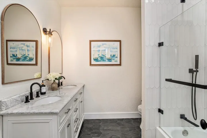 Guest bath with marble topped vanity, dual sinks and tub/shower combination