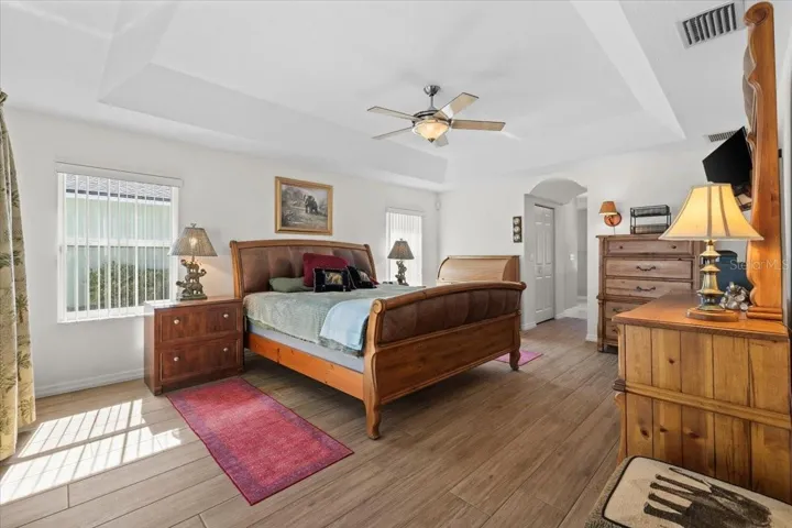 Elegant primary suite with tray ceilings and a private ensuite bath. Enjoy direct access to the lanai and pool for a true resort-style retreat.