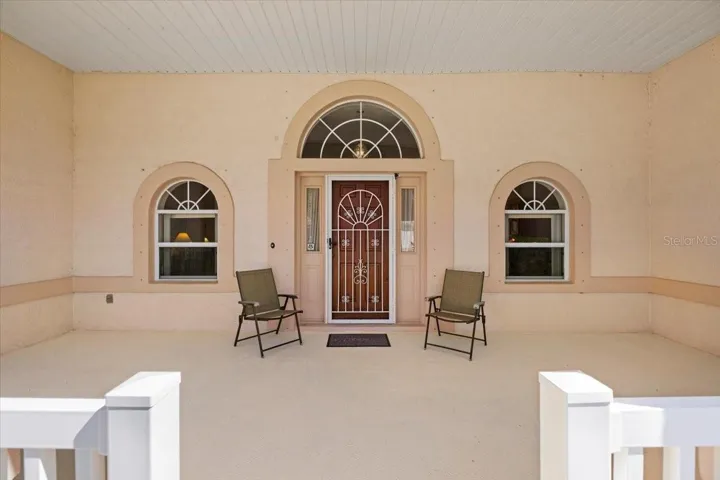 Inviting covered entry with charming architectural details, offering abundant space for morning coffee or evening relaxation