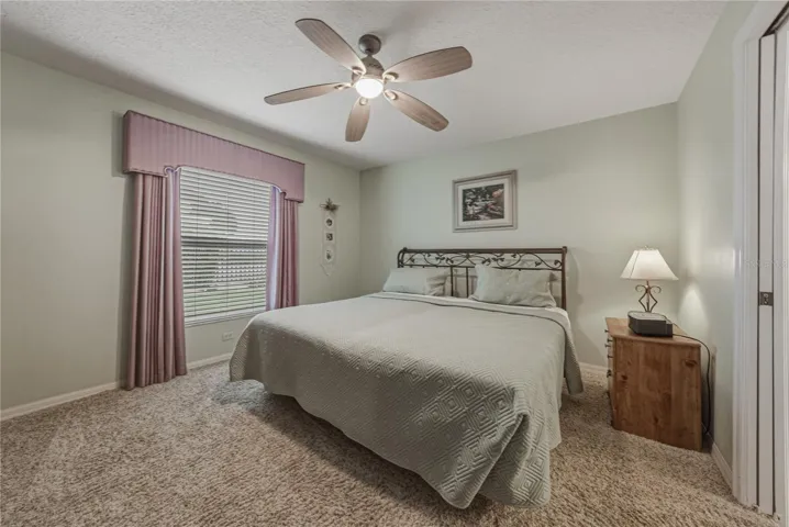 The primary bedroom is at the rear of the home and has a ceiling fan with light and quality carpeting.