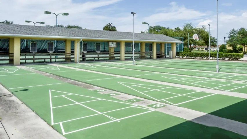 The lighted shuffleboard courts are on the main clubhouse grounds. The outdoor basketball court is in the background.
