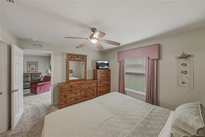 The primary bedroom has a ceiling fan with light and quality carpeting.