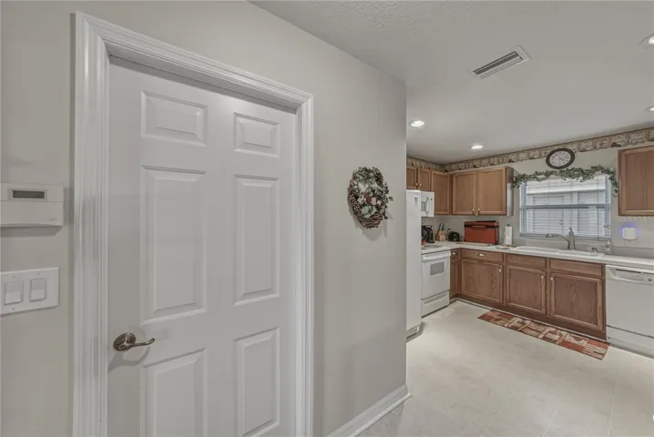 The doorway to the garage is in the foyer adjacent to the kitchen.