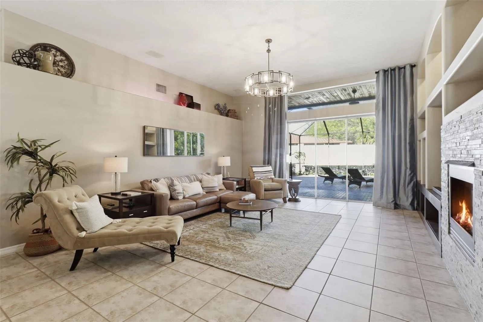 Open living room adjacent to the kitchen, featuring abundant natural light and views of the pool -perfect for indoor-outdoor living