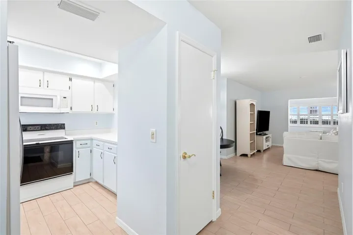 Foyer area looking into kitchen on left & living room in background