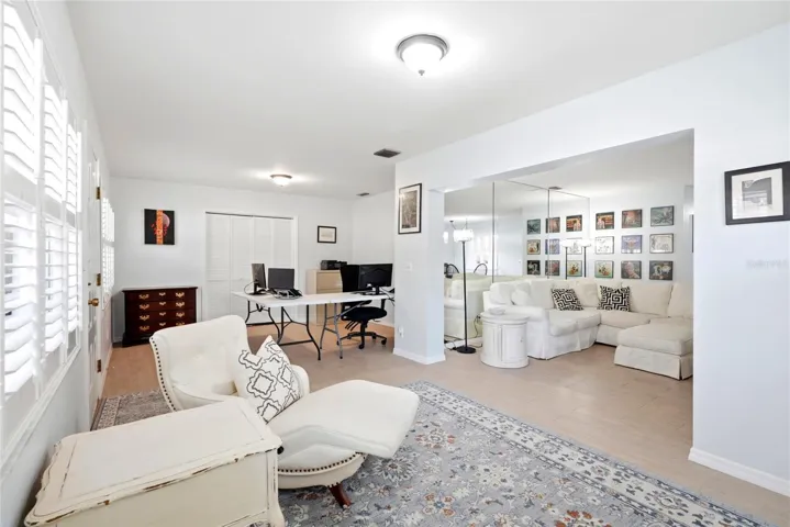 Florida room with office space in the background and living room on the right.